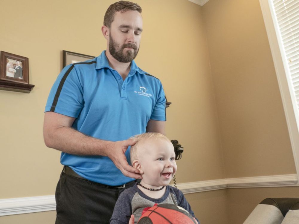 Dr. Kenny Strack gently checking a smiling young patient